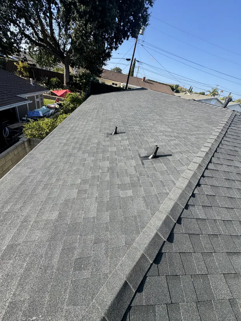 Finished charcoal architectural shingle roof with new pipe flashings and a clean ridge line.