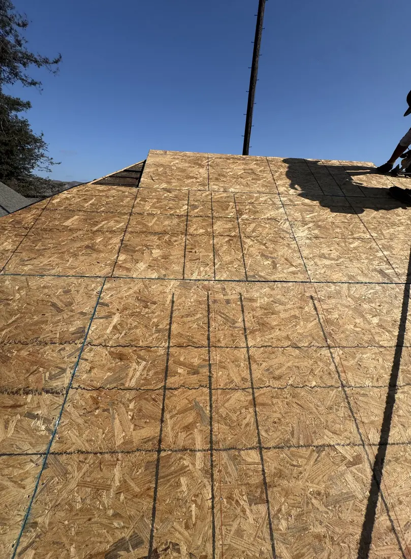 New plywood decking installed across a slope with chalk lines snapped for the new lay.
